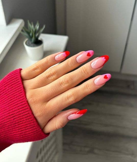 Eclectic nail art featuring different red designs on each finge
