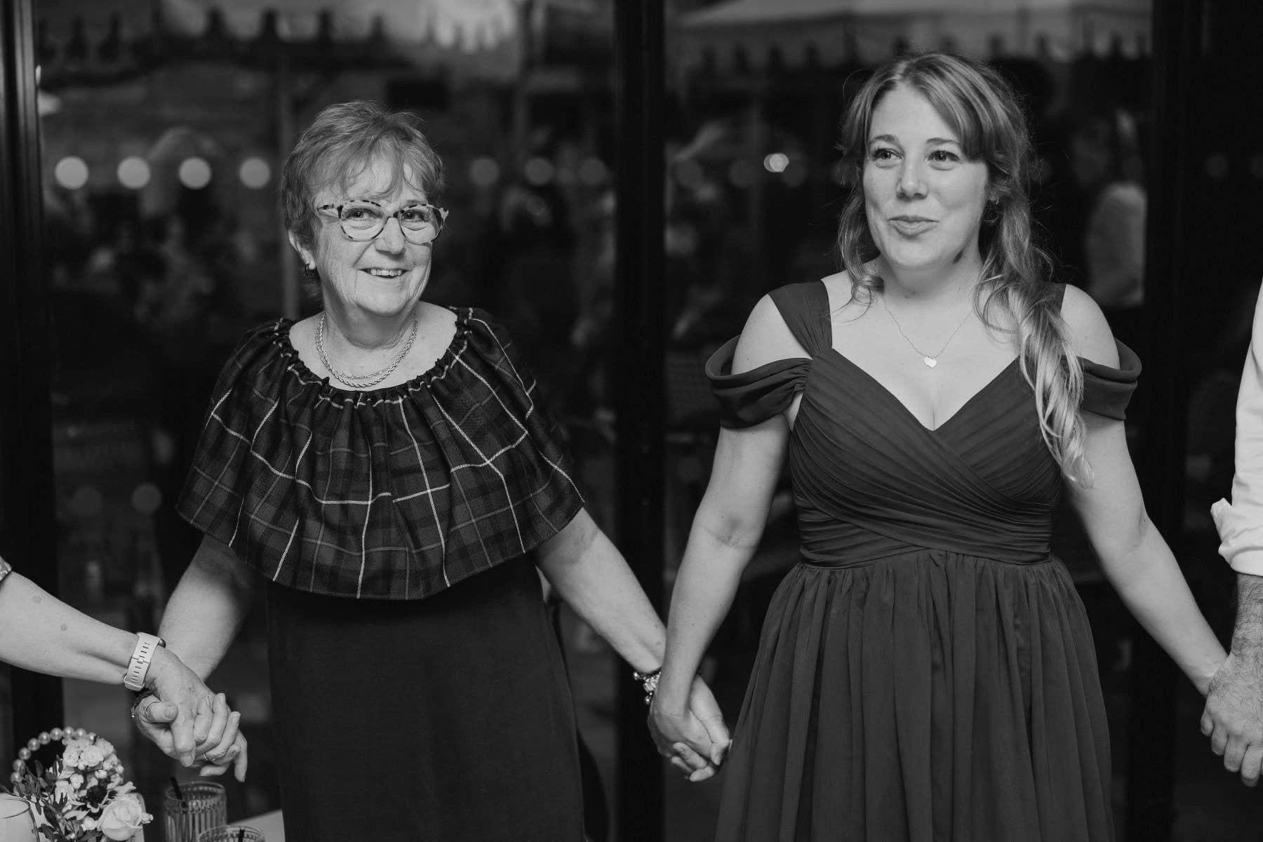 two women holding hands as they dance