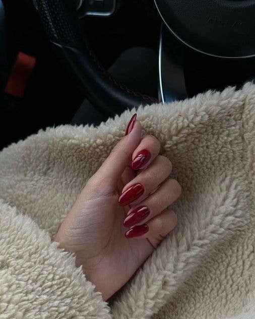 Flawless high-shine classic red manicure on short, neat nails.