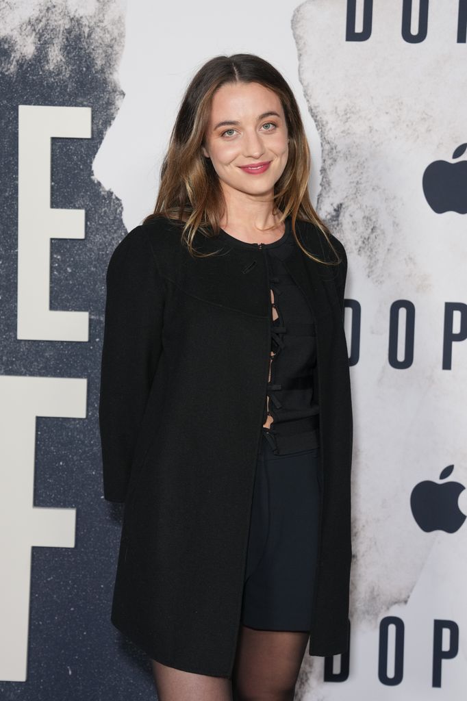 Stella Baker holds her hands behind her back and is dressed in all blaack at the series premiere of 'Dope Thief'.
