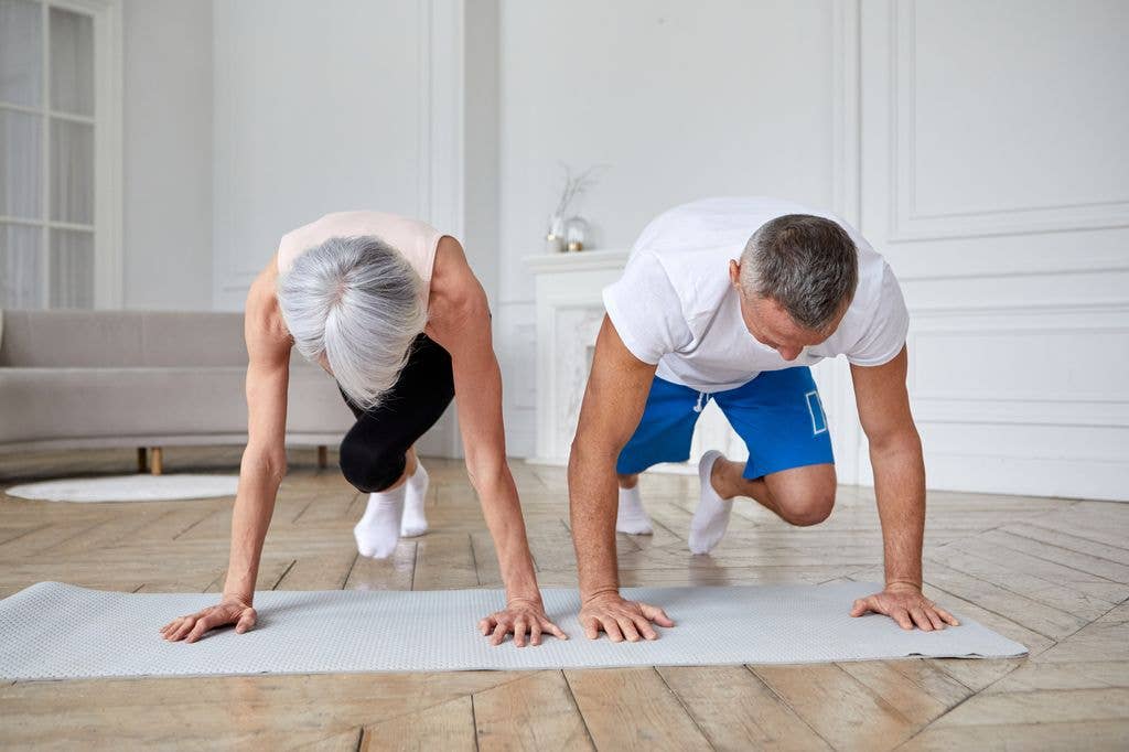 senior couple doing mountain climbers