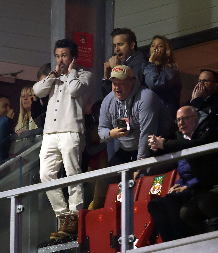 Rob McElhenney, Actor and Co-Owner of Wrexham, Ryan Reynolds, Actor and Co-Owner of Wexham, and Actress Blake Lively react after Josh Acheampong of Chelsea (not pictured) scores his team's second goal 