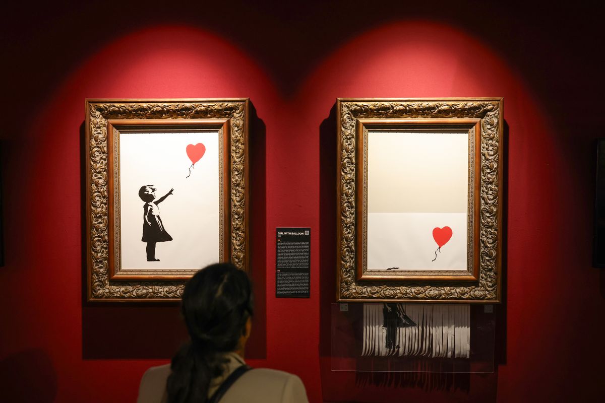  A visitor views the Banksy works 'Girl With Balloon' during the exhibition "The Mystery of Banksy - A Genius Mind" 