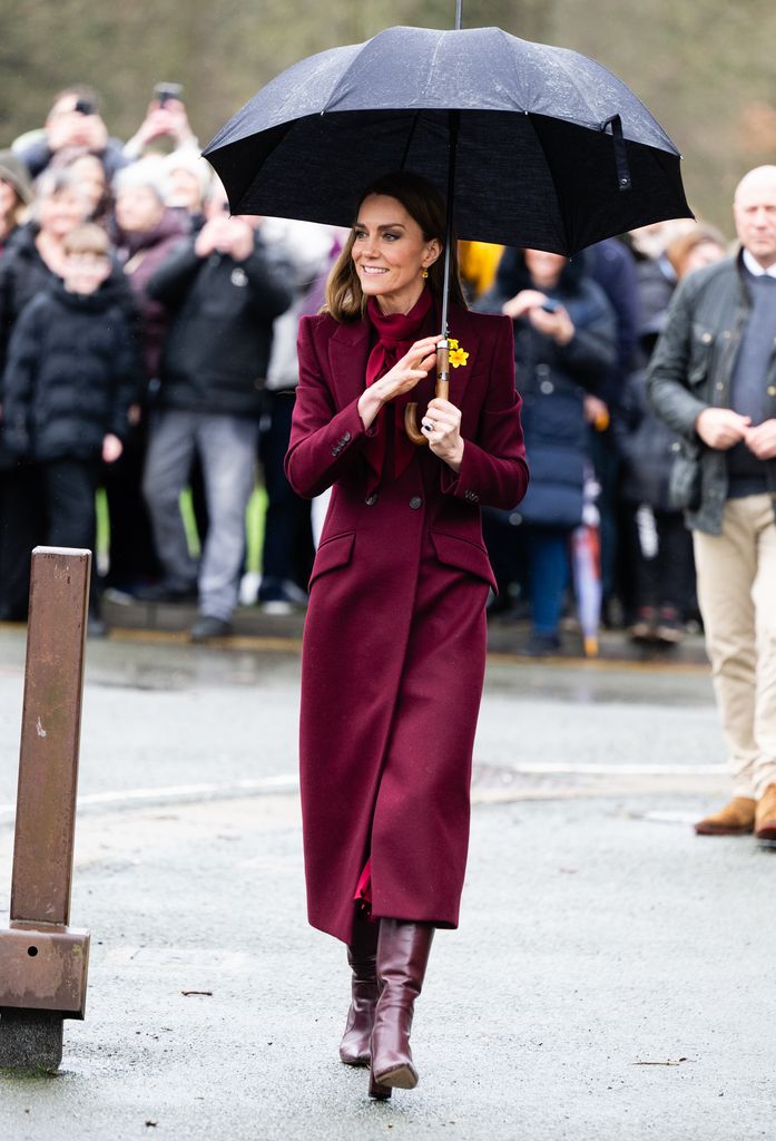 The Princess of Wales in burgundy outfit holding umbrella
