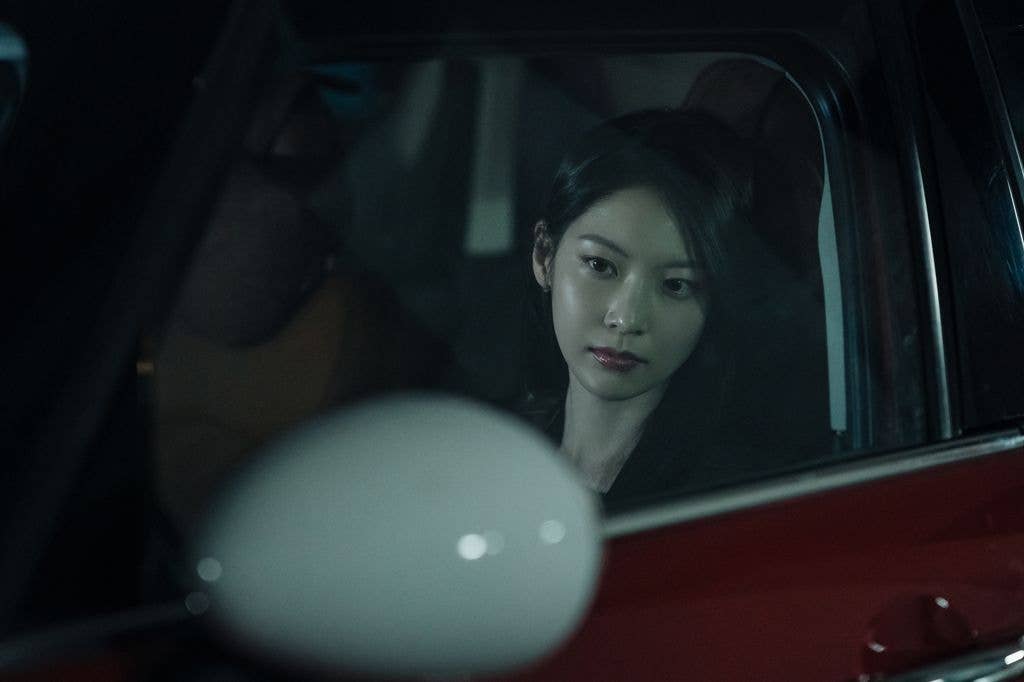 Gong Seung-yeon sitting in a red car in a still from Karma
