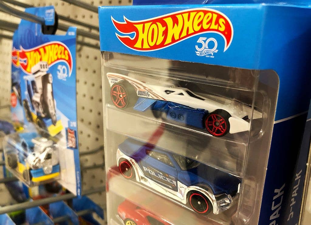 Hot Wheels cars stacked in plastic packaging.