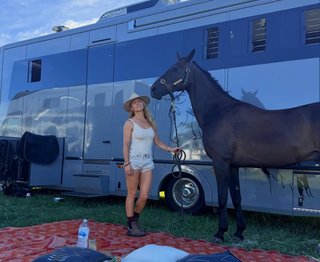 Pataky standing beside her horse in casual riding attire