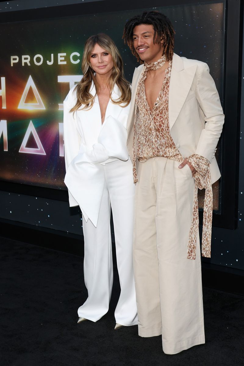 Wearing a cream-colored linen suit with exaggerated balloon pants, Henry elevated the look with a bold, deep V-neck leopard-print shirt