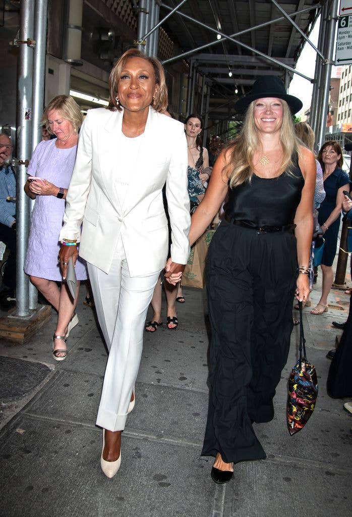 Robin Roberts in white suit and Amber Laign in black jumpsuit seen arriving at the Broadway show "Call Me Izzy" on June 12, 2025 in New York City