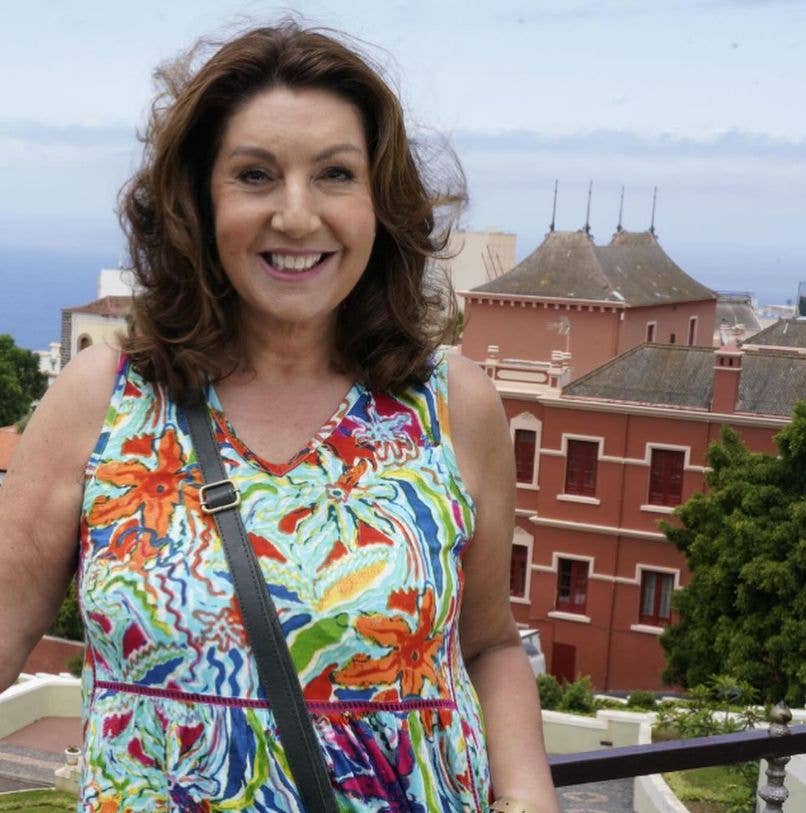 Jane McDonald in front of several buildings