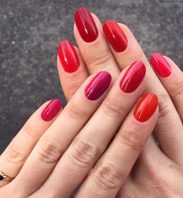 Five different shades of red polish, one on each finger