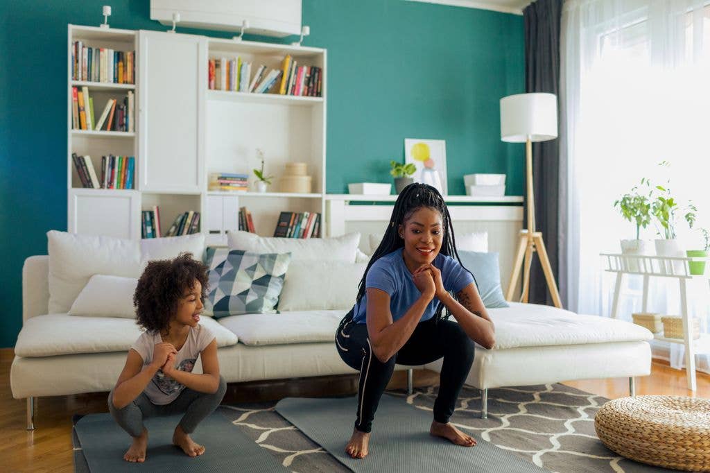 woman exercising with child at home in living room