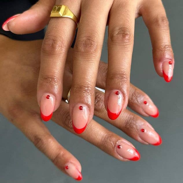 Red French manicure with a pearlescent finish and tiny red dots