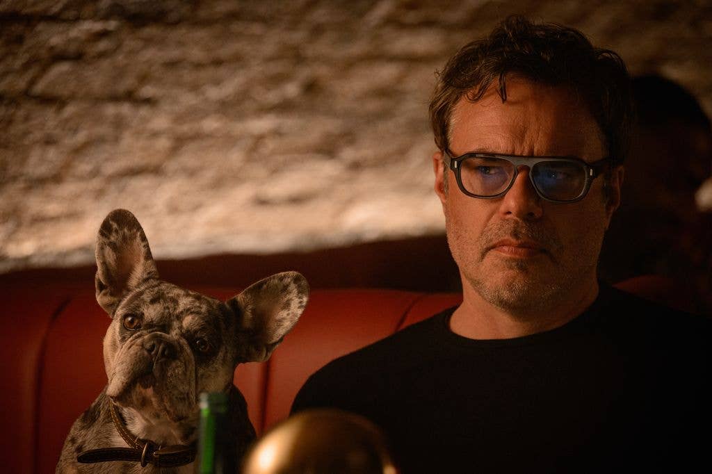 man sitting next to dog in dimly lit room