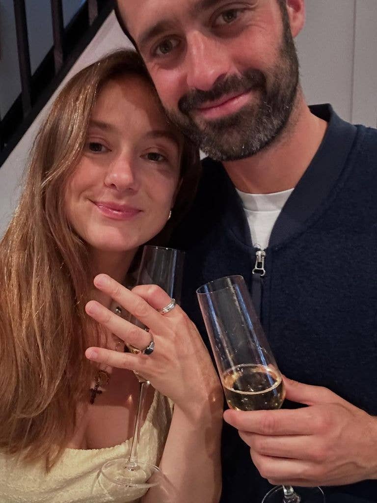 woman and man drinking champagne to celebrate engagement news