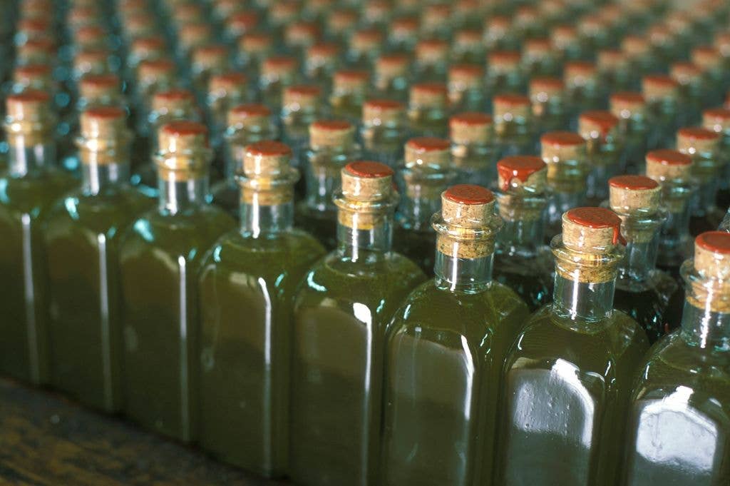 Corked and wax sealed glass olive oil bottles filled with organic extra virgin olive oil.