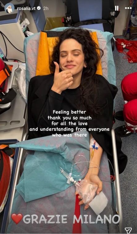 Rosalía shared a photo to her Instagram Story on March 26 showing herself on a stretcher with an IV in her arm, giving a thumbs-up to reassure fans.