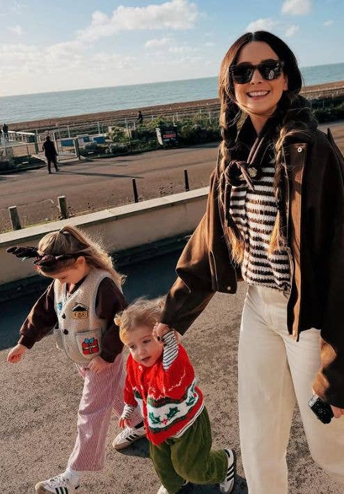 Zoe Sugg walking with her two daughters by the beach