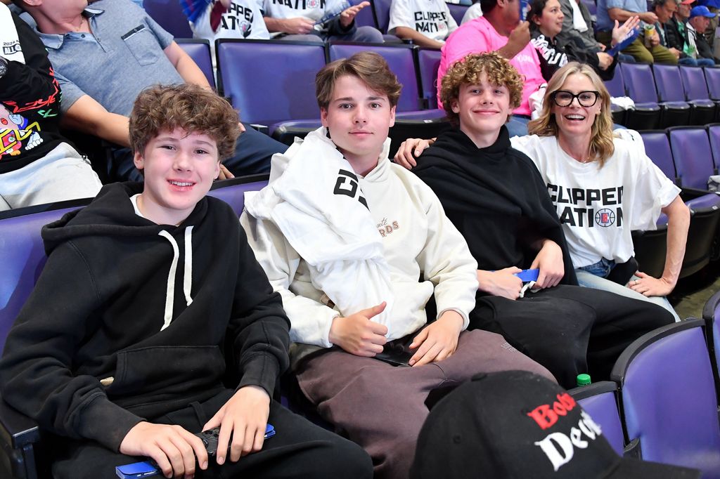 Julie Bowen sits next to her three children at a basketball game.