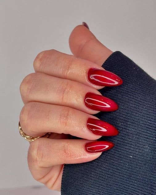 Red ombré nails transitioning from dark crimson to light scarlet.