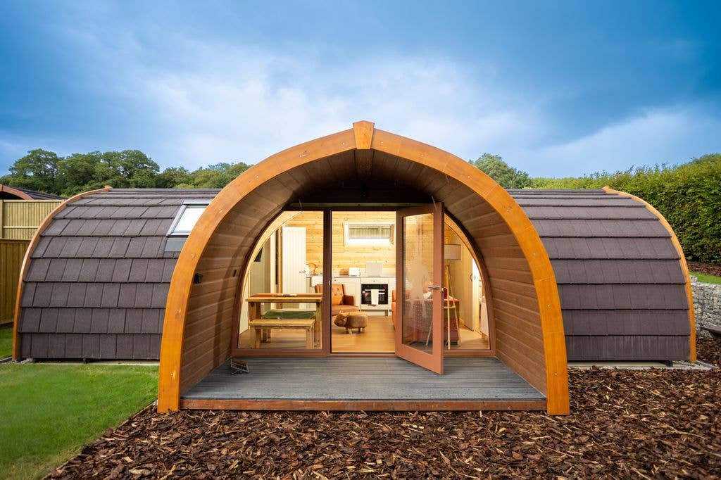 Lodge from the front with open door and lights on inside