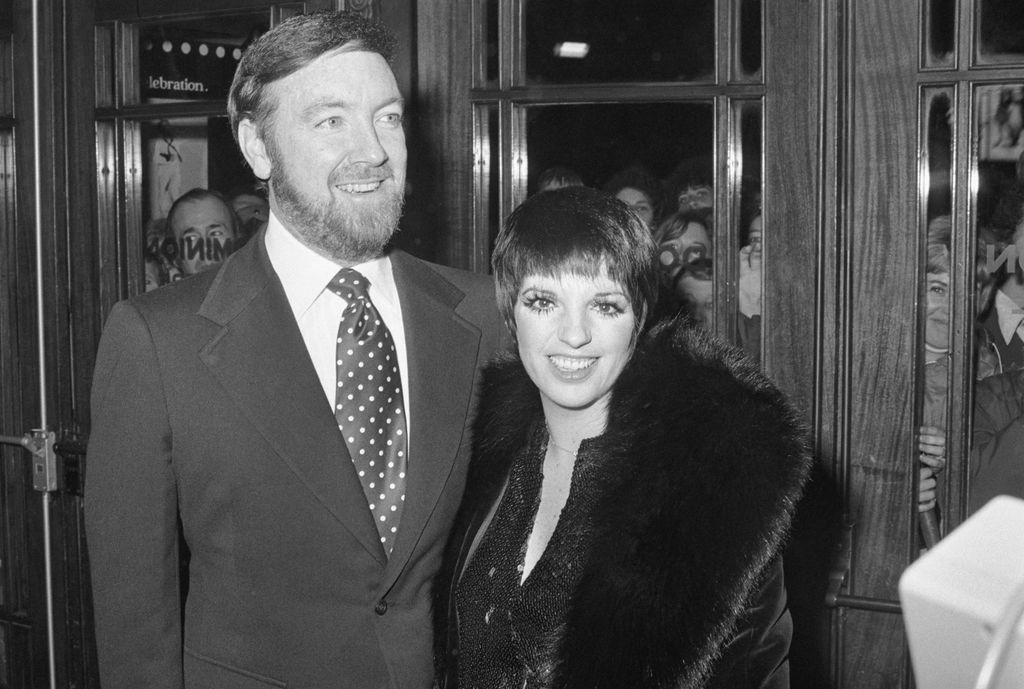 Liza Minnelli in a fur coat arriving at a premiere with husband Jack Haley Jr who wears a suit and spotted tie.