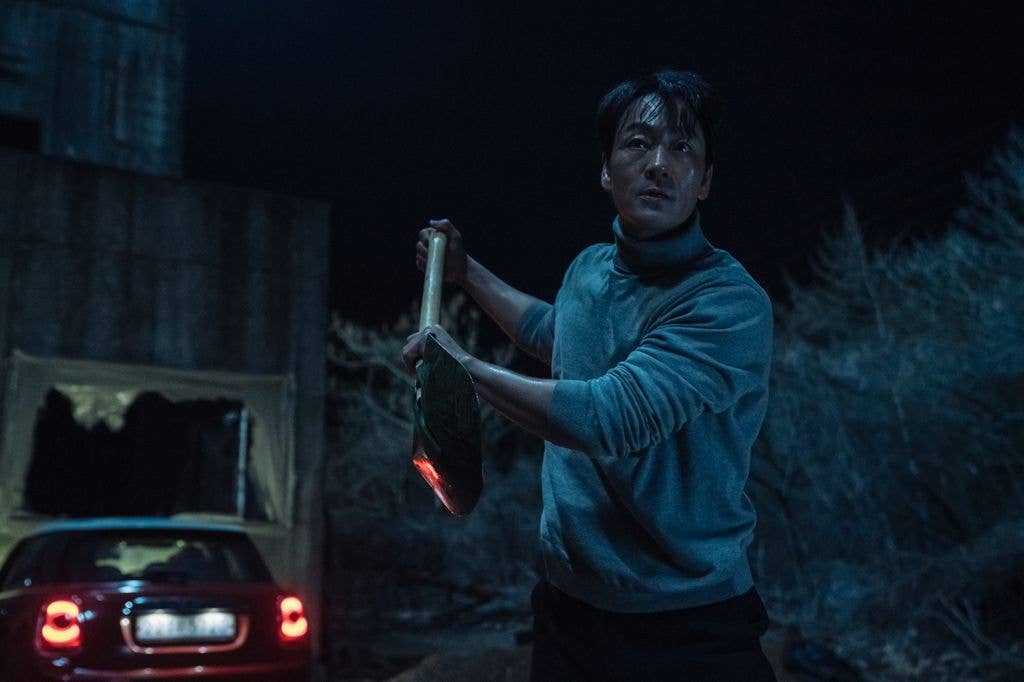 Park Hae-soo holding a shovel in the dark in a still image from Karma