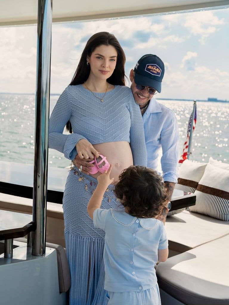 Marc and Nadia posing on boat in blue outfits with son Marco