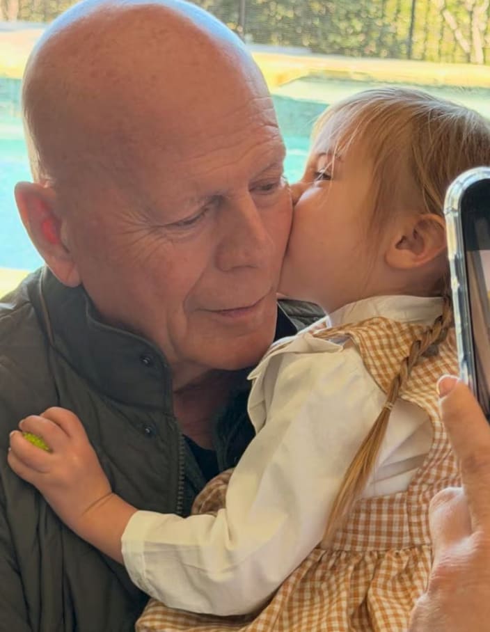 In the image, the toddler, who is about to turn three, sits in Willis’ arms while planting a kiss on him, capturing a tender family moment