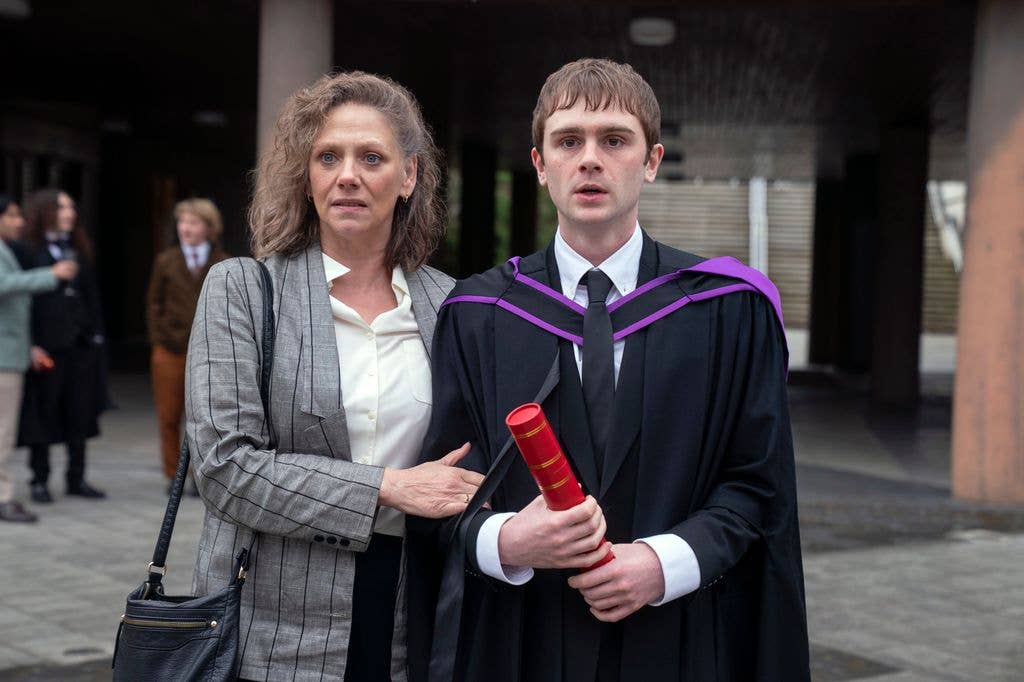 uni student at graduation with mother