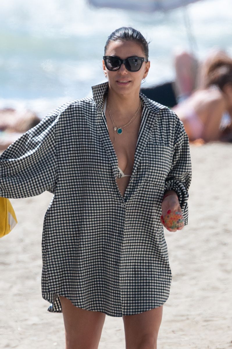  The oversized shirt adds volume, so the fitted bikini underneath keeps the look structured.

