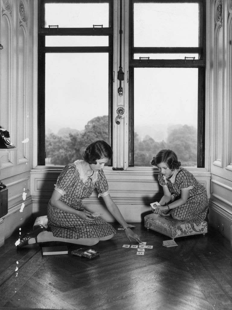 two young ladies playing cards sitting on the floor