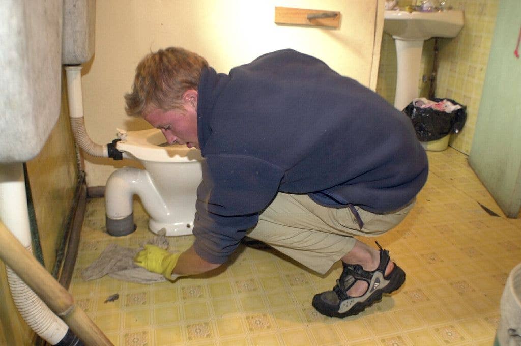 Prince William cleans toilet at accommodation in the village of Tortel, Southern Chile during his Raleigh International Expedition