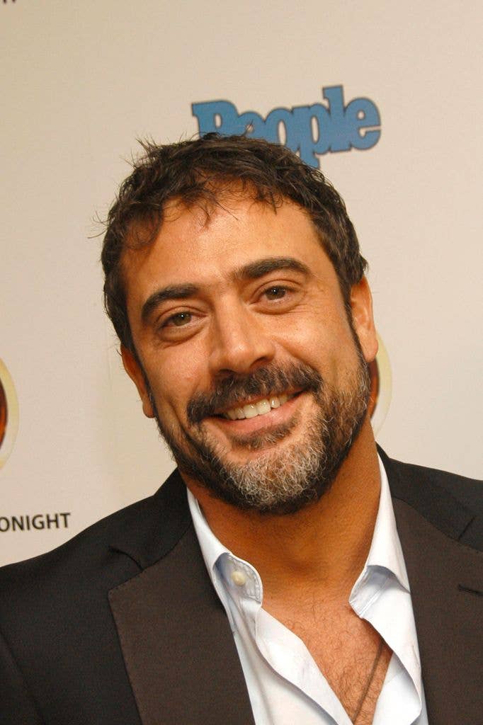 Headshot of Jeffrey Dean Morgan in a suit with his white shirt open at the neck, smiling at the camera.
