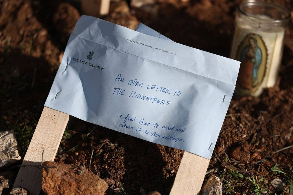 An open letter to the kidnappers sits in a memorial set up next to the driveway of Nancy Guthrie's residence