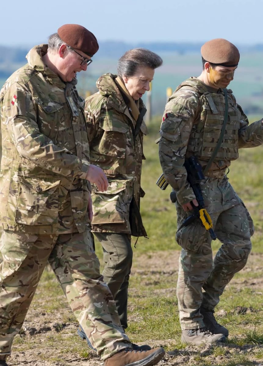 Princess Anne speaks with soldiers on the coordination of tanks, infantry, and drones in modern military operations.