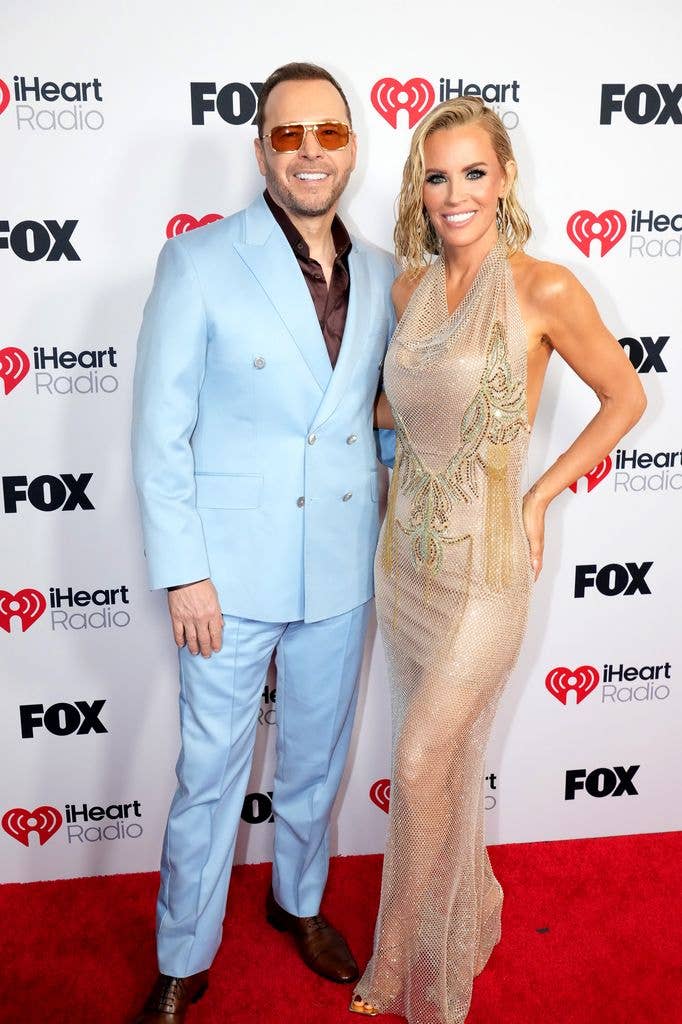 photo of jenny mccarthy in gold dress and donnie wahlberg in blue suit red carpet