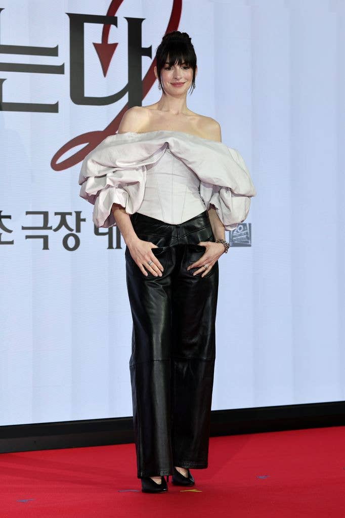 Anne Hathaway with new bangs in grey top and leather trousers