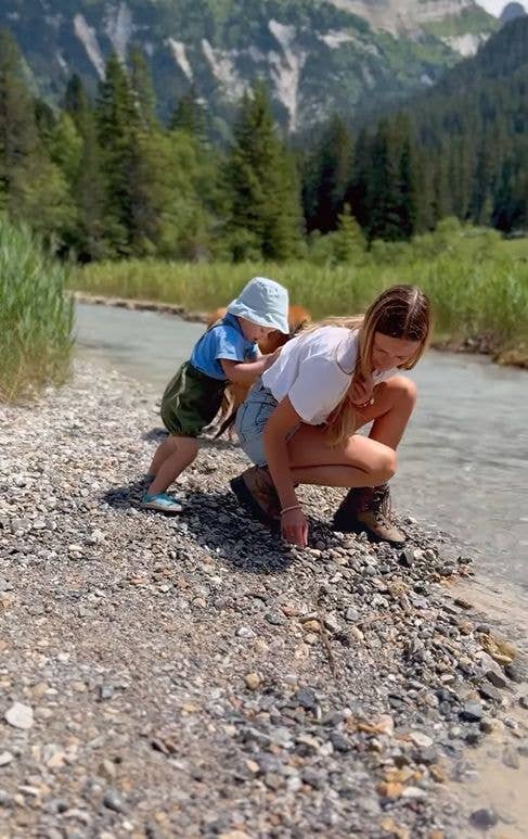 A young boy attempting to push his mother