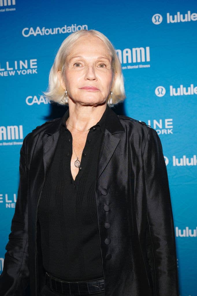 Ellen Barkin in a black top under a thin shiny black shirt, her light blonde hair bobbed.