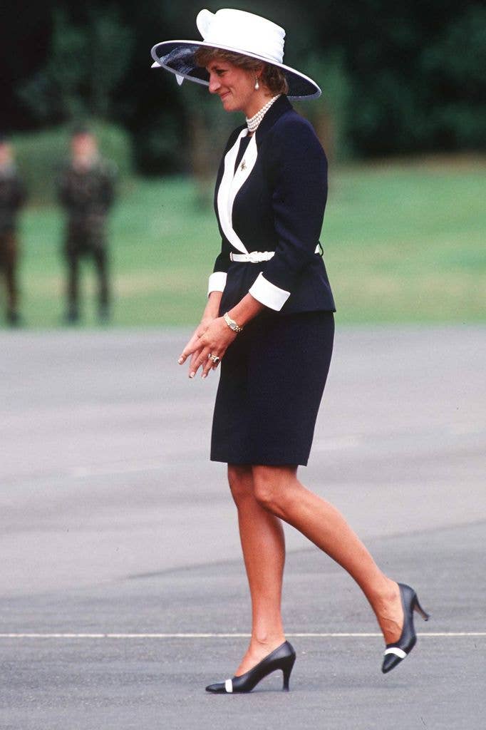 Diana side on walking in navy and white skirt suit
