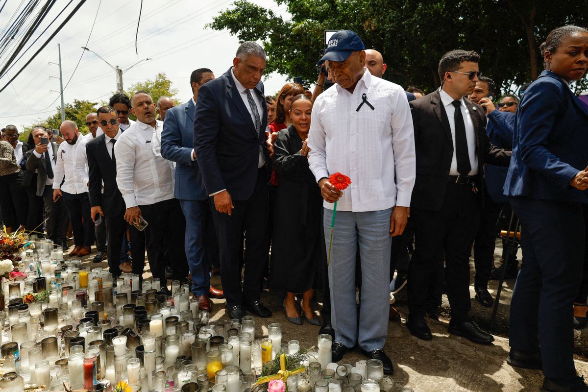 New York's former Mayor Eric Adams (C) holds a red flower as he walks in front of the Jet Set night club in Santo Domingo on April 14, 2025. 