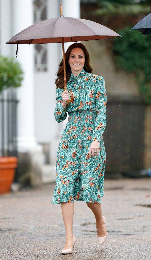 Kate in green printed dress under umbrella