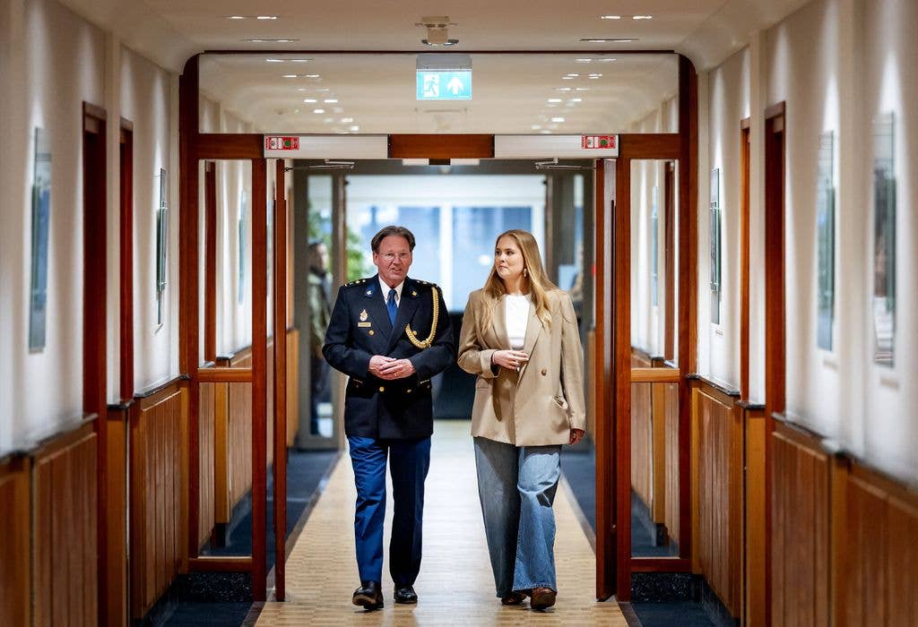Princess Amalia of the Netherlands (R)and Amsterdam police chief Peter Holla walking through corridor