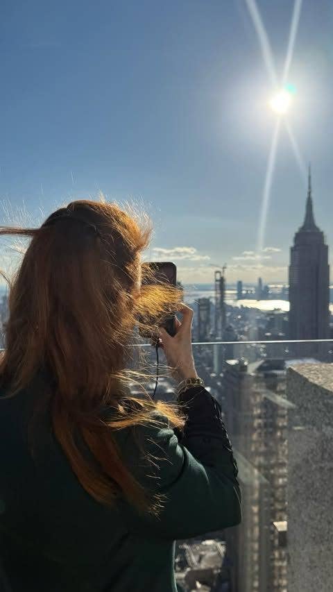 woman taking picture of New York skyline
