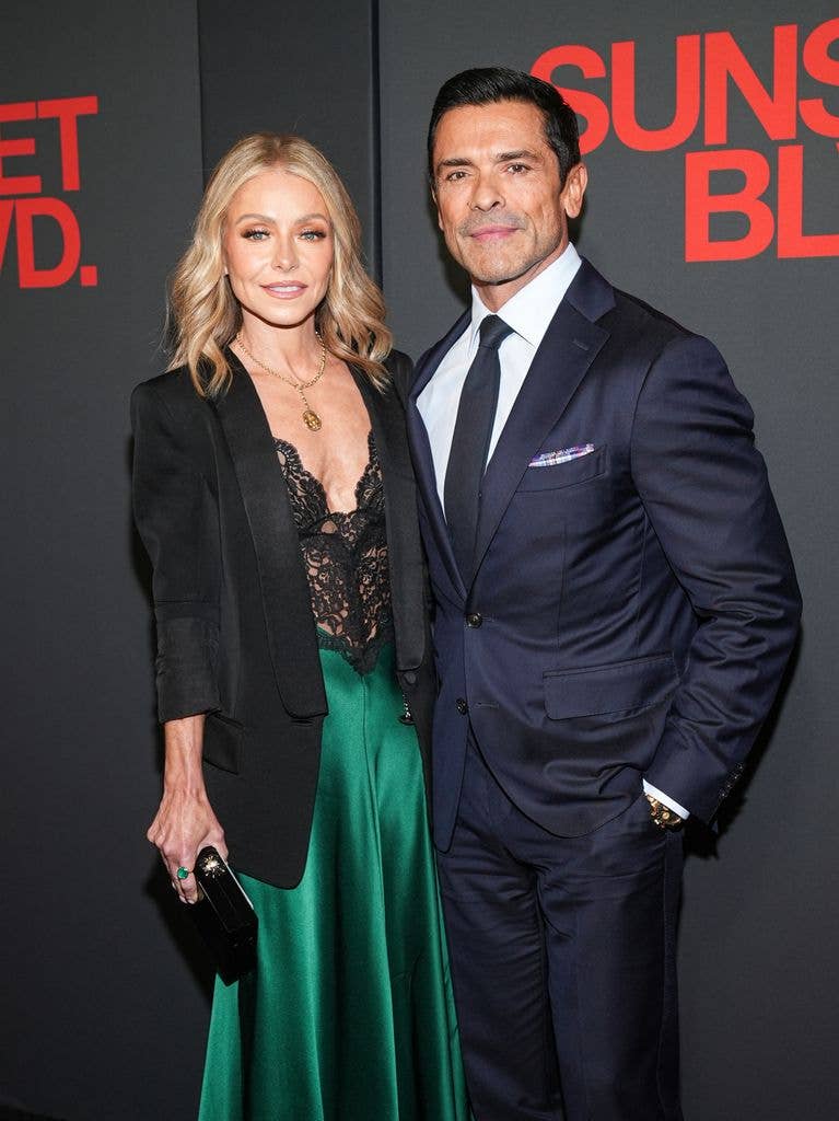 Kelly Ripa in black blazer and lace dress and Mark Consuelos in navy suit 