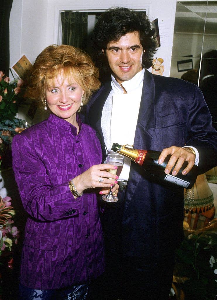 John Frieda pouring champagne into a glass held by Lulu