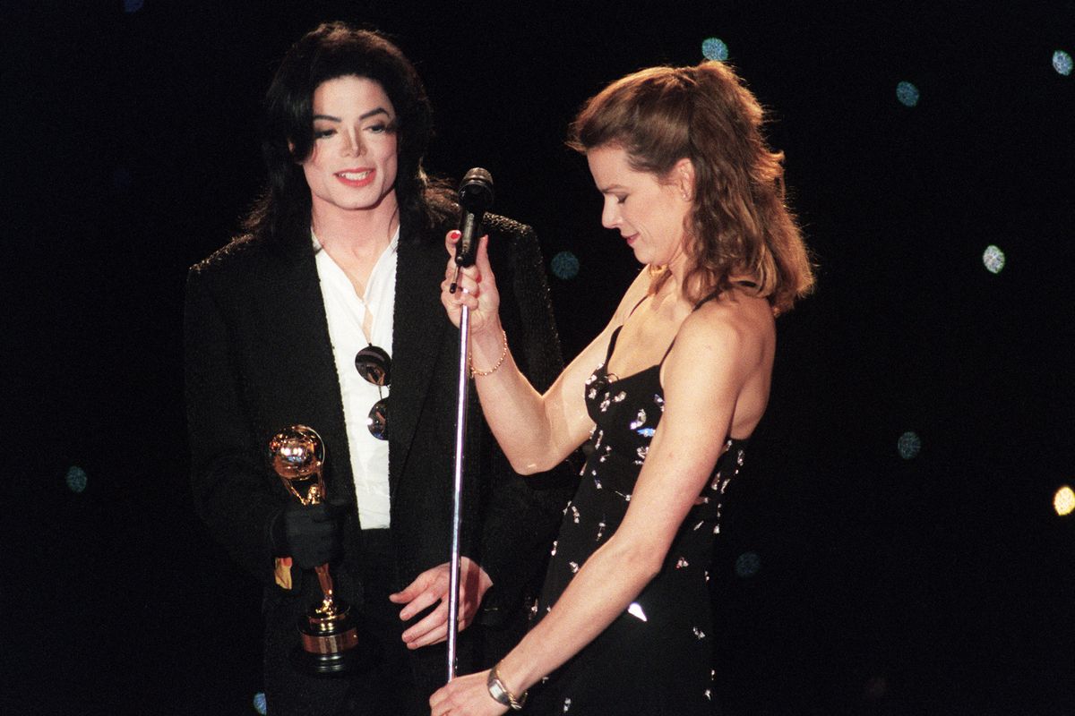 Princess Stephanie of Monaco fixes the microphone for US singer Michael Jackson on May 8, 1996 in Monaco after he was given the best musical album of all times award during the World Music Awards ceremony