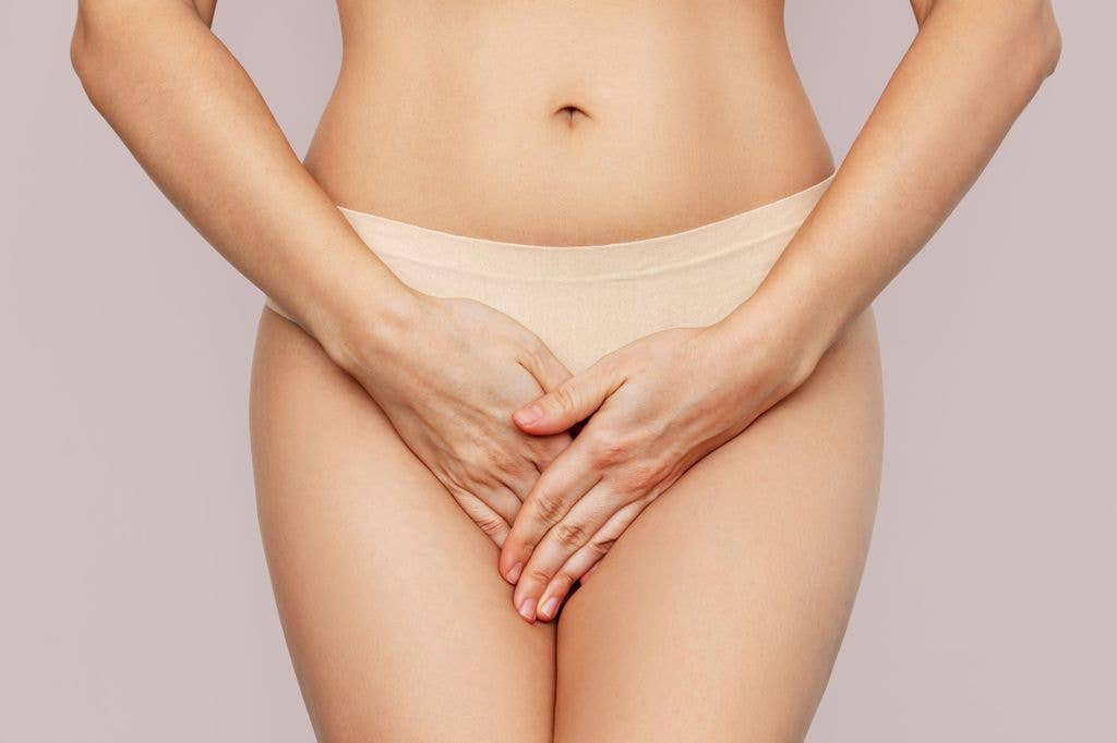 woman in beige underwear covering crotch area