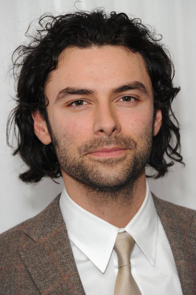 Aiden Turner in a light brown check suit, white shirt and champagne tie.